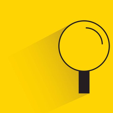 Sarı arka planda gölgesi olan büyüteç.