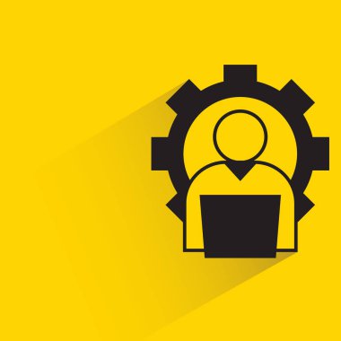 Sarı arkaplanda dişli simgesi olan bir adam dizüstü bilgisayarda çalışıyor