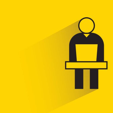 Adam sarı arkaplanda dizüstü bilgisayar simgesi üzerinde çalışıyor