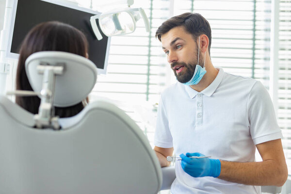 caucasian dentist talking with patient in clinic