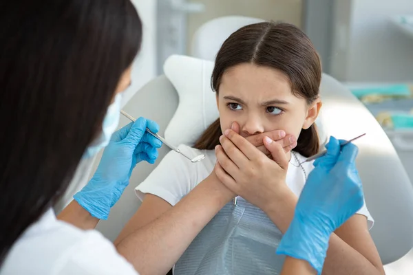 Menina Assustada Sentado Cadeira Dental Cobrindo Boca Com Mãos — Fotografia de Stock