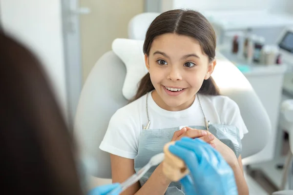 Médico Mostrando Como Escovar Dentes Modelo Mandíbulas Para Menina Sentada — Fotografia de Stock