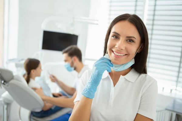 Lächelnde Ärztin Die Die Kamera Blickt Während Ihr Kollege Hintergrund — Stockfoto