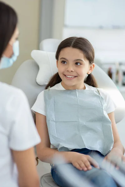 Retrato Menina Sorrindo Olhando Para Médico Sentado Cadeira Consultório Dentista — Fotografia de Stock