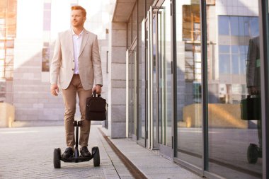 Gülümseyen zarif adam kendini dengeleyen bir taşıyıcı kullanıyor ve merakla etrafa bakıyor.