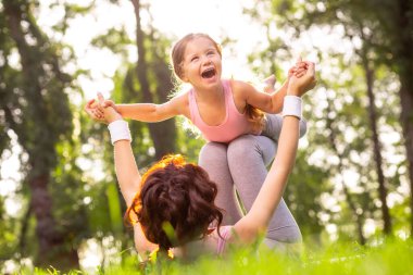 Kadının portresi çimenlerin üzerinde uzanıyor. Parkta sevgilisini bacaklarının üzerinde tutuyor.