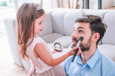 Kafkasyalı baba ve kız makyaj fırçasıyla evde oynuyorlar.