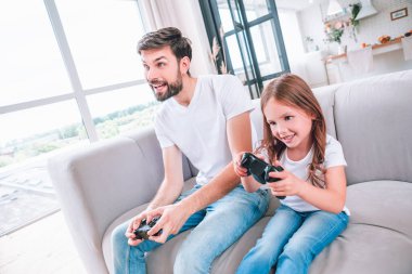 duygusal baba ve kızı oturma odasında bilgisayar oyunu oynuyorlar.