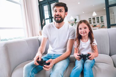 duygusal baba ve kızı oturma odasında bilgisayar oyunu oynuyorlar.