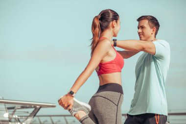 Sabah köprüde antrenmandan önce iki kişi bacaklarını ısıtıyordu.