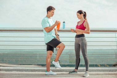 Eğitimden sonra köprüde duran genç adam ve kadının tam boy çekimi.