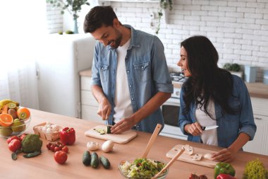 Çift ev mutfağında birlikte yemek hazırlıyor.