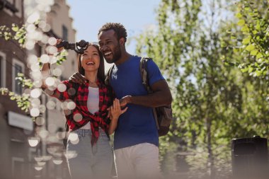 Erkek arkadaş ve kız arkadaş sokakta bir video için kameraya poz veriyorlar.