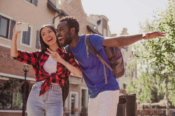 happy couple taking selfie on smartphne in the city