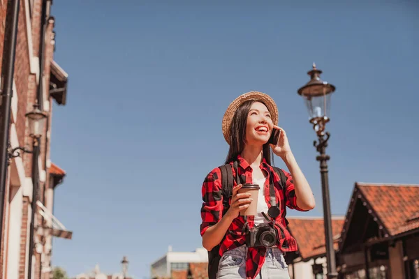 Kobieta Turysta Słomkowym Kapeluszu Mówi Smartfonie Spacerując Ulicy Słoneczny Dzień — Zdjęcie stockowe