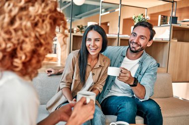 Bayan danışman, müşterilerle kafede buluşuyor. Kahve içip muhabbet eden pozitif bir çift ve bayan arkadaş.