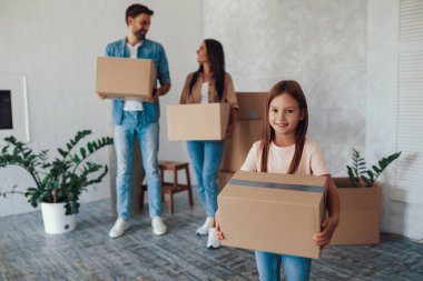 Yardımsever küçük çocuk ve heyecanlı ailesi yeni yaşam alanlarına karton kutular getiriyorlar.