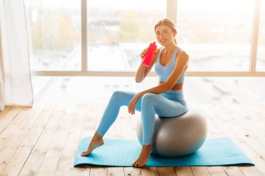 Sıska genç bir kadın spor yaparken spor yapmaya ara veriyor.