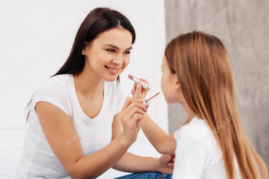 Joyful young family doing makeup for each other with pleasure