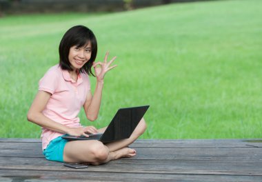 Kullanma bilgisayar parkta oturan kadın