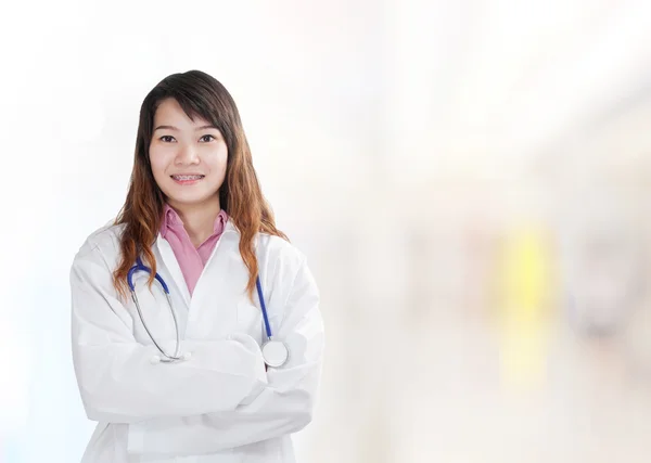 Femme médecin à l'hôpital avec des patients à l'arrière-plan — Photo