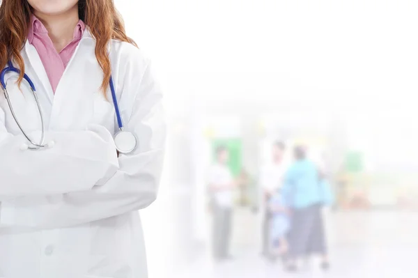 Femme médecin à l'hôpital avec des patients à l'arrière-plan — Photo