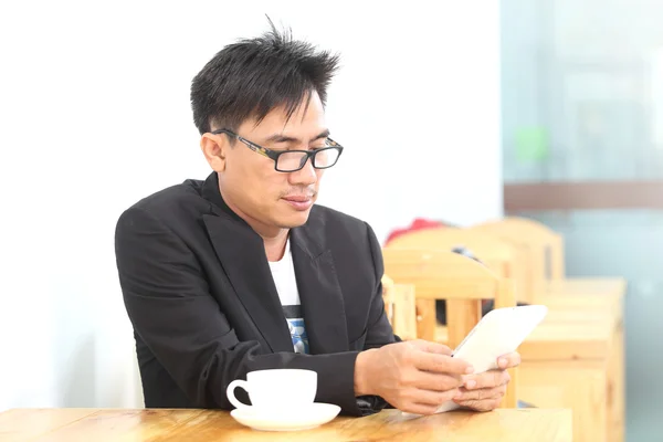 Zakenman met smartphone in een koffieshop Stockfoto