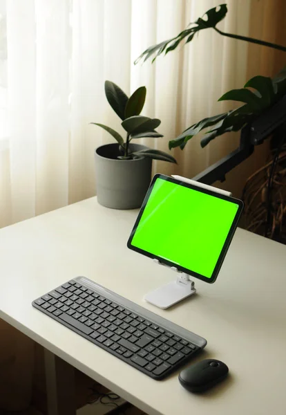 Tablet em stand com teclado e mouse. Minimalismo interior com plantas de casa — Fotografia de Stock