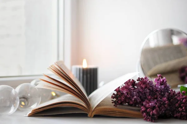 Çiçeklerle açılmış bir kitap. Evdeki sıcak bahar havası. Çiçekli leylak