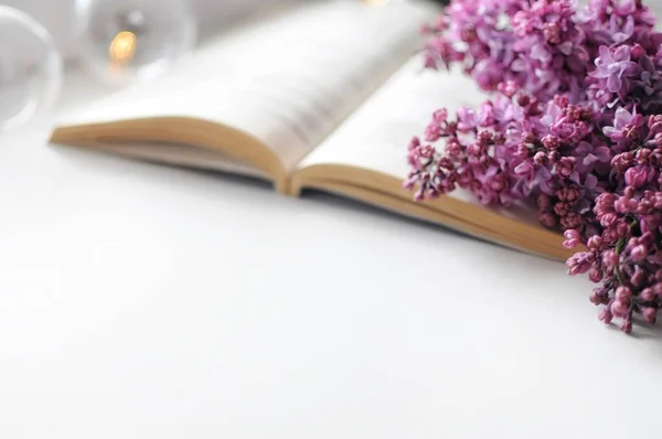 Açılmış kitap ve leylak çiçekli pankart. Romantik atmosfer.