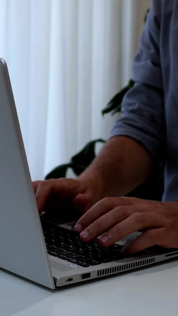 Κάθετη βίντεο του νέου που εργάζονται σε φορητό υπολογιστή.Εργασία από το σπίτι μινιμαλισμός εσωτερικό — Αρχείο Βίντεο