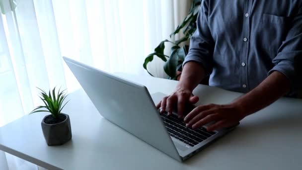 Junger Mann arbeitet am Laptop. Arbeit von zu Hause aus — Stockvideo