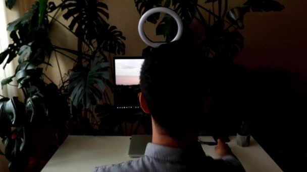 Jongeman bereidt zich voor op de online ontmoeting door een ringlicht te controleren — Stockvideo