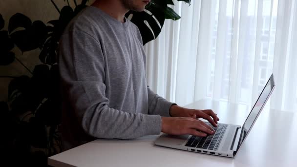Um jovem trabalhando em laptop.Work de casa minimalismo interior — Vídeo de Stock