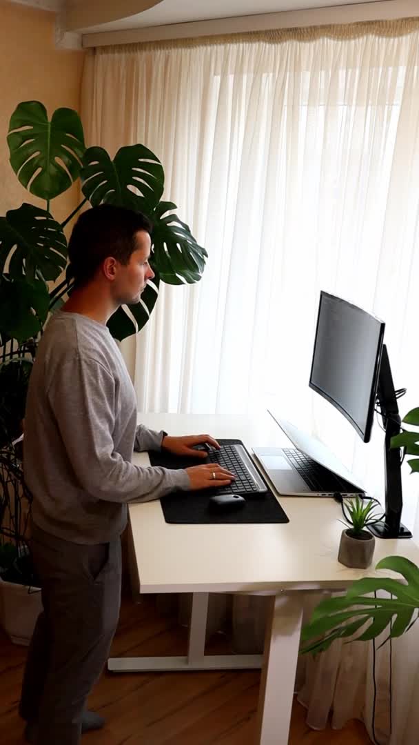 Vídeo vertical do jovem trabalhando em laptop.Work de casa minimalismo interior — Vídeo de Stock