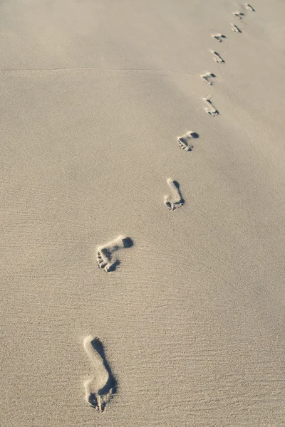 Pegadas na areia da praia do mar — Fotografia de Stock