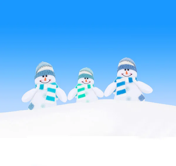 Inverno snowmen família contra o céu azul — Fotografia de Stock