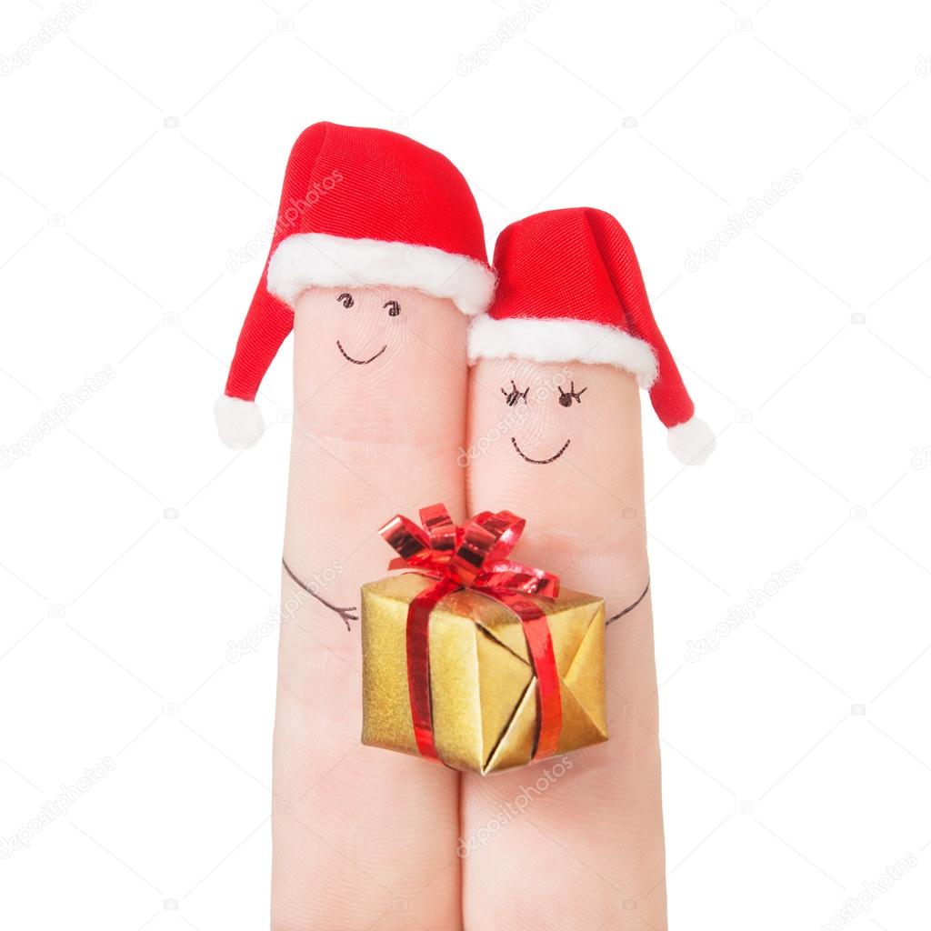 Fingers faces in Santa hats with gift box