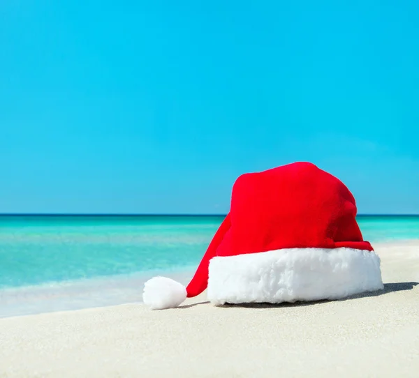 Chapéu de Natal de Santa na areia branca da praia tropical — Fotografia de Stock