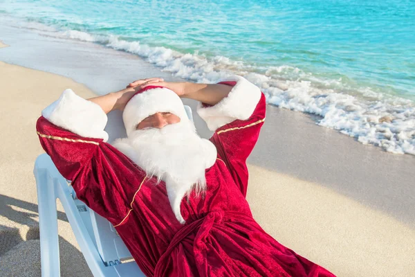 Weihnachtsmänner ruhen sich in der Lounge am Strand aus — Stockfoto