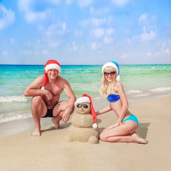 Sandy boneco de neve e jovem casal — Fotografia de Stock