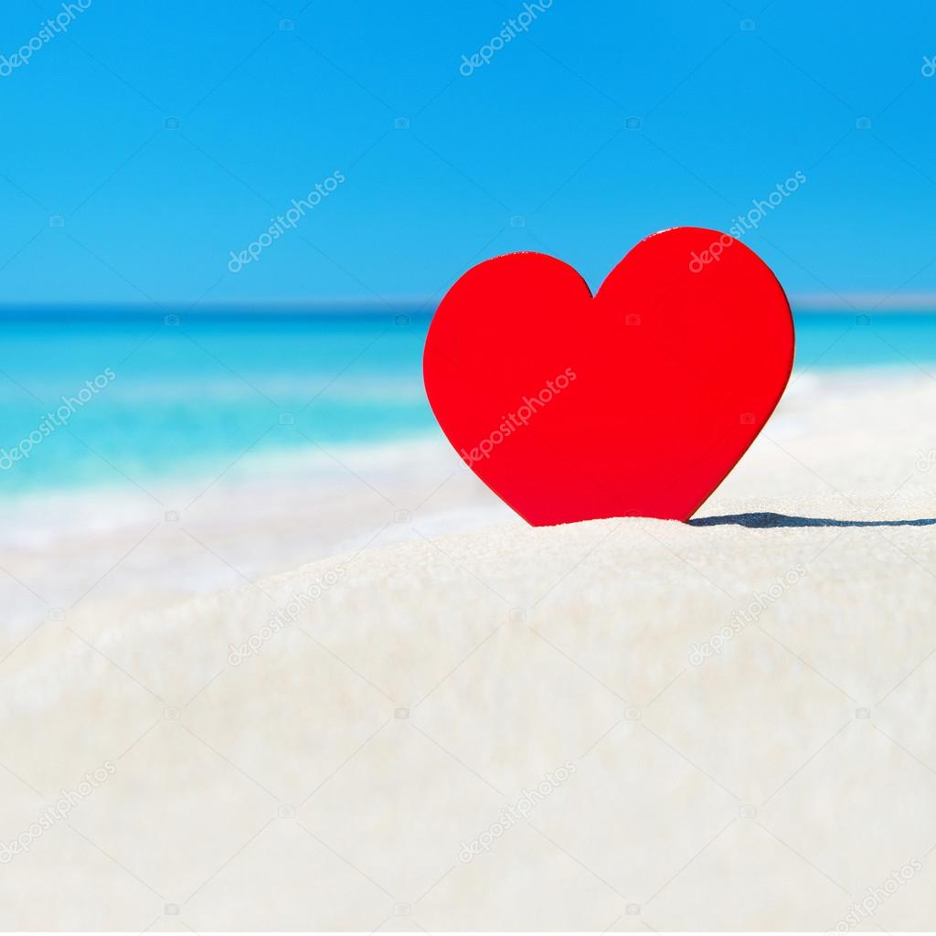 Red heart in sand