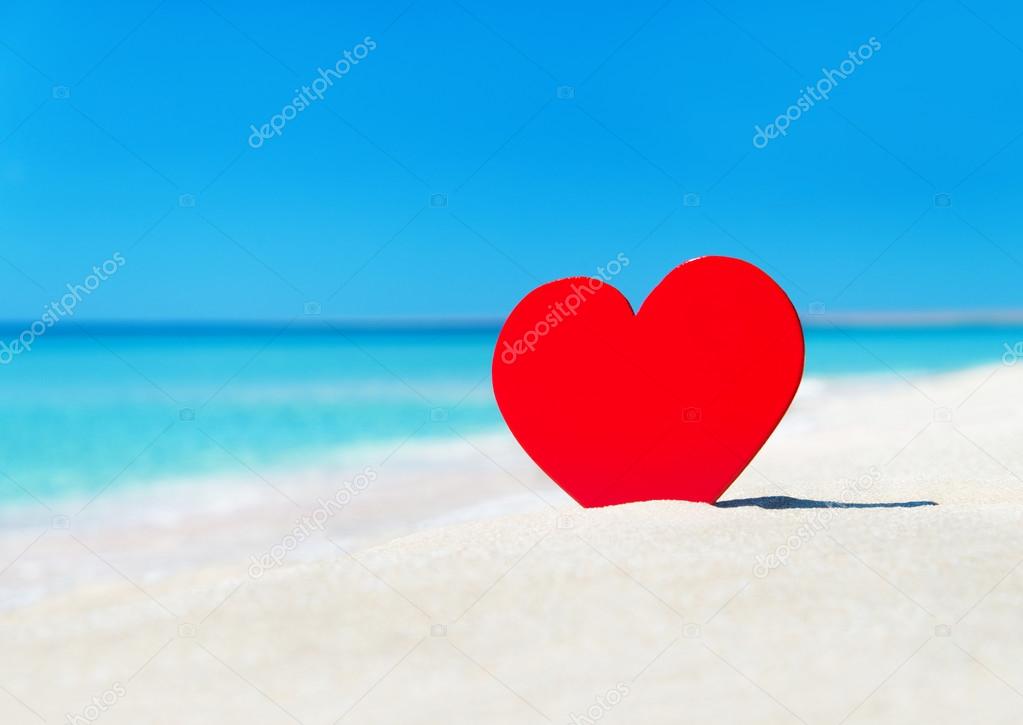 Red heart in sand
