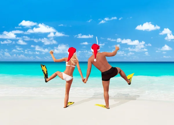 Casal romântico em santa chapéus na praia — Fotografia de Stock