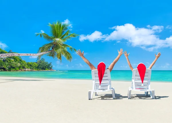 Романтическая пара в шляпах Санты на пляже — стоковое фото