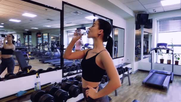 Ein Schönes Fitnessmodel Fitnessstudio Trinkt Aus Einer Flasche Und Blickt — Stockvideo