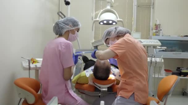 Escritório Dentista Jovem Dentista Juntamente Com Assistente Estão Tratando Paciente — Vídeo de Stock