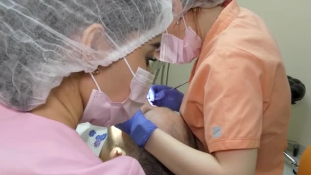 Jovem Dentista Trata Dentes Homem Primeiro Plano Jovem Assistente Prepara — Vídeo de Stock