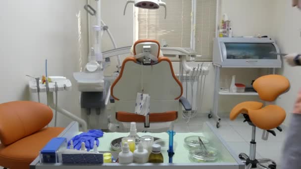 歯医者の事務所だ 医者は患者を待っている間に椅子に座り 電話を見続けます — ストック動画