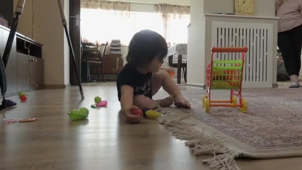 Une Femme Âgée Tient Debout Regarde Comme Petit Enfant Assis — Video